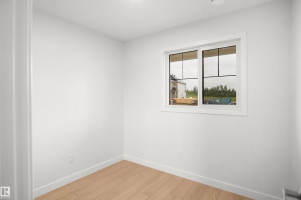 Cozy living area with large windows, light-colored furniture, and potted plant - 13133 214 St Nw, Edmonton