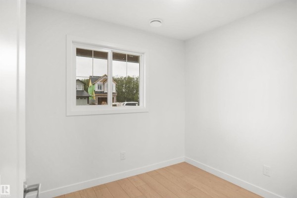 Living room with sectional sofa, wall-mounted TV, and decorative plant - 13135 214 St Nw, Edmonton
