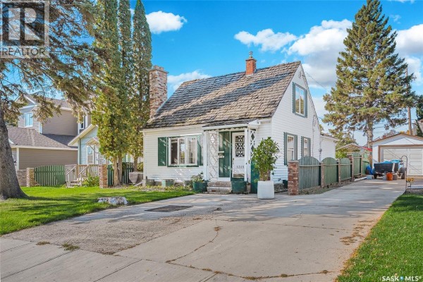 Side view of the white house with green shutters and a long driveway. - 1315 2nd Avenue N, Saskatoon