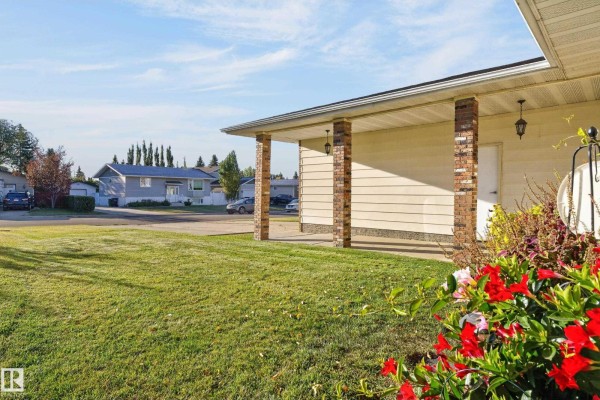 View of the street from the front yard, showing neighboring houses and trees. - 1316 85 St Nw, Edmonton