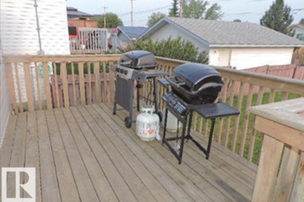 Wooden deck with two barbecues and propane tanks. - 1318 8 Av, Cold Lake