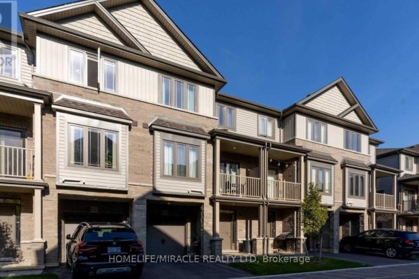 Entrance foyer with a white front door, sidelight windows, and a double closet. - 132 - 77 Diana Avenue, Brantford