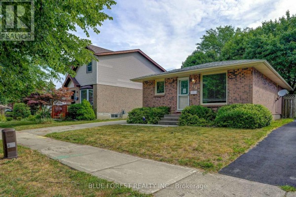Side exterior view of a brick bungalow with a concrete driveway and lawn. - 132 Ardsley Crescent, London North