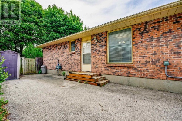 Rear exterior of a brick bungalow with a wooden deck and purple shed. - 132 Ardsley Crescent, London North