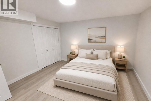 Empty room with light wood laminate flooring, white walls, and a single window. - 132 East 31st Street, Hamilton