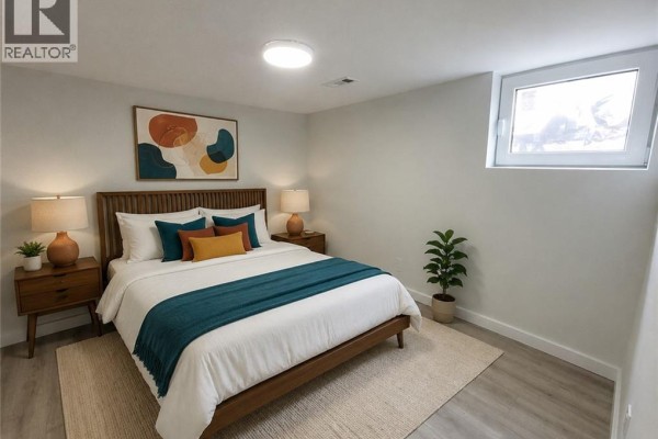 Room with light wood laminate flooring, white walls, bi-fold closet doors, and a doorway to another room. - 132 East 31st Street, Hamilton