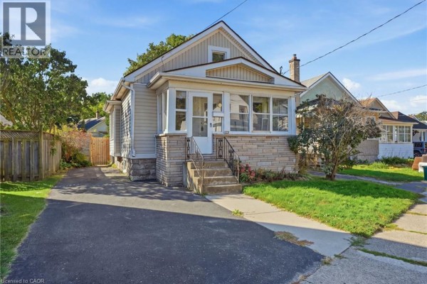 View of the front of the bungalow from the driveway, showing a side path. - 132 Grass Avenue, St  Catharines