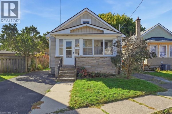 Front exterior of the bungalow with a stone foundation and an enclosed front porch. - 132 Grass Avenue, St  Catharines