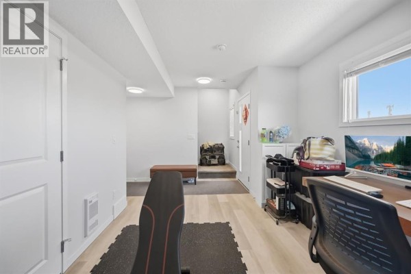 Interior room showing a home gym area with weights, bench, and desk. - 132 Harvest Grove Walk Nw, Calgary
