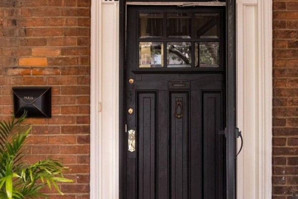 Close-up of the black front door with a glass pane, knocker, and mail slot. - 132 Herkimer Street, Hamilton
