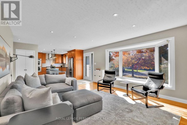 Modern kitchen with cherry wood cabinets, granite countertops, stainless steel appliances, and a large island. - 1321 Rustic Drive, Ottawa