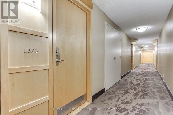 The main building lobby with glass doors, wood paneling, and tiled floors. - 1323 - 18 Mondeo Drive, Toronto