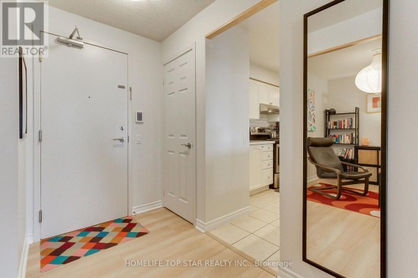 A hallway on a residential floor with multiple doors and patterned carpeting. - 1323 - 18 Mondeo Drive, Toronto