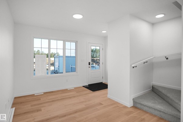 Interior entryway with a white bench, coat rack, and wood-look flooring. - 1324 9 St Nw, Edmonton