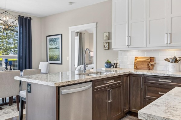 Kitchen island with granite countertop, stainless steel dishwasher, and subway tile backsplash. - 1324 Stromdahl Place, Mt Woodside, Agassiz