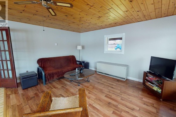 Exterior of a wood-sided house with a covered porch and a satellite dish. - 13249 Nova Scotia 7 Highway, Aspen