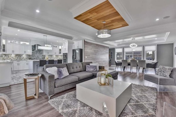 Living room with grey sofas, fireplace, built-in white cabinets, and patterned rug. - 13291 Melville Place, Surrey