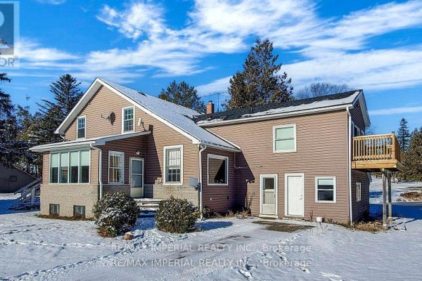 Rear view of a two-story house with a deck and snow on the ground in winter. - 13291 Warden Avenue, Whitchurch Stouffville