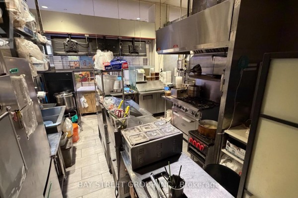 Commercial kitchen with stainless steel counters, stoves, ovens, range hood, and food preparation equipment. - 133 - 4750 Yonge Street, Toronto