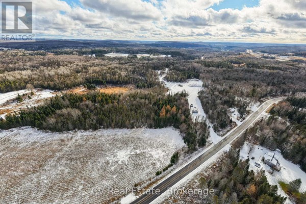 Aerial view of a snow-covered landscape with forested areas and a meandering path. - 133 Berriedale Road, Armour
