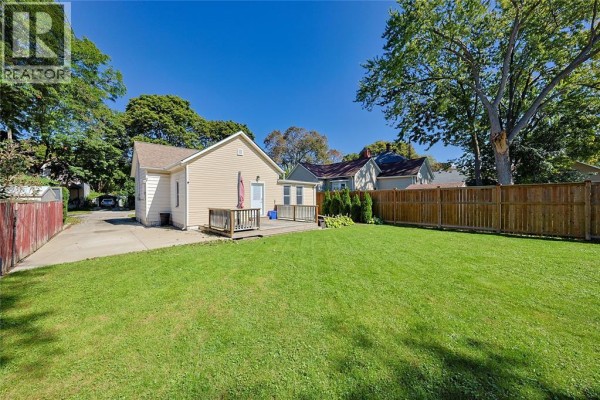 Rear view of the 133 Bright Street bungalow showing the deck, backyard, and driveway. - 133 Bright Street, Sarnia