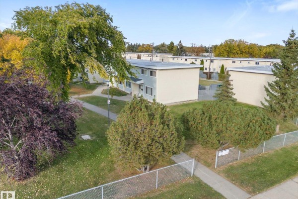 Aerial view of a townhouse complex surrounded by mature trees and green grass. - 13307 89a St Nw, Edmonton
