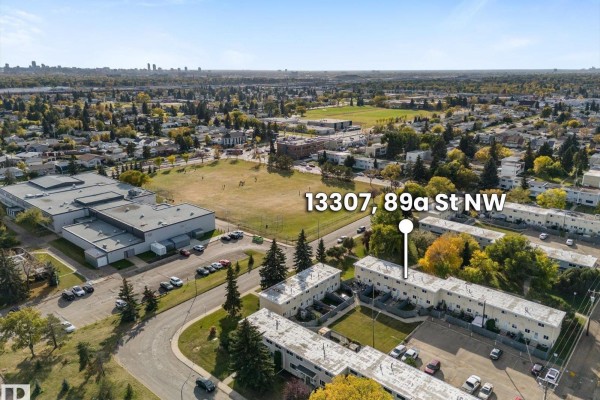 Aerial view of townhouses in Edmonton with a park and city skyline in the distance. - 13307 89a St Nw, Edmonton
