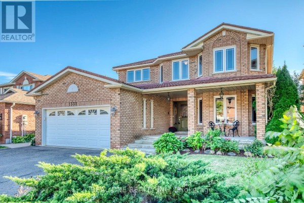 Front exterior of a brick house with a double garage and covered porch during daytime. - 1332 Greenwood Crescent, Oakville