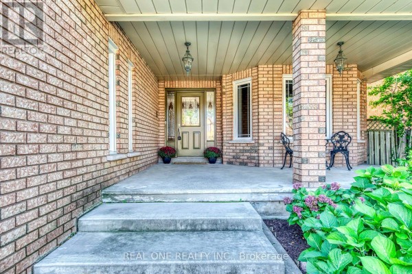 Concrete porch entrance with brick pillars, a double front door, and two outdoor chairs. - 1332 Greenwood Crescent, Oakville