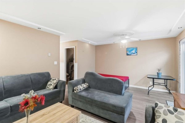 Living room with beige walls, two sofas, a chaise lounge, and a red daybed. - 13323 71b Avenue, Surrey