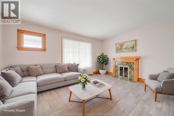 Living room with a grey sectional sofa, coffee table, and a decorative fireplace. - 1333 Windermere Unit# Room, Windsor