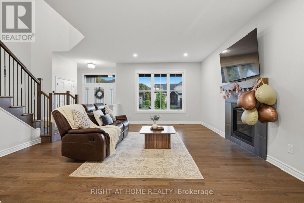 Hallway and staircase with dark wood railings and white doors, leading to the kitchen. - 1334 Fribourg Street, Russell