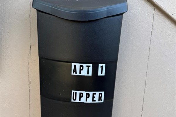 Black trash bin with white lettering reading 'APT 1 UPPER'. - 1337 Assumption Street Unit# 1, Windsor