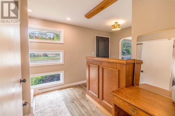 Interior view of an entryway with horizontal windows, a wooden desk, and a wooden partition. - 134 Florwin Dr, Sault Ste  Marie