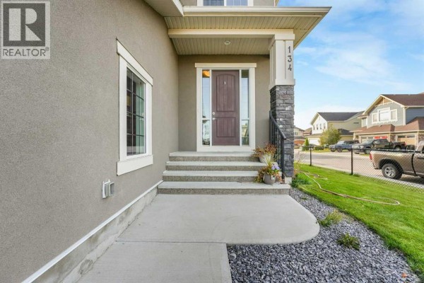 Close-up of the front entrance stairs and door of a two-story house. - 134 Kinniburgh Lane, Chestermere