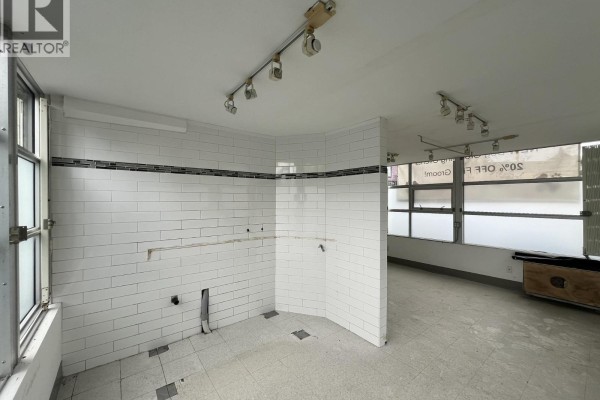 Interior room with dark wood laminate flooring, gray walls, and multiple doorways. - 1340 W 4th Avenue, Vancouver