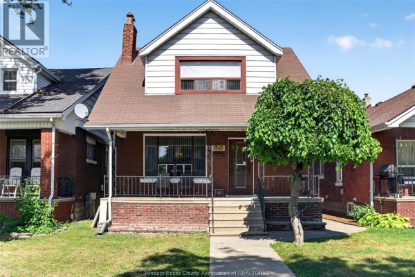 Front exterior of a two-story brick house with white siding and a pitched roof. - 1342 Hall Avenue, Windsor