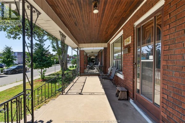 Covered porch with brick walls, wooden ceiling, and a view of the street. - 1342 Hall Avenue, Windsor