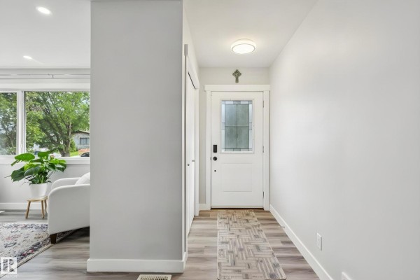 Another view of the living area with two armchairs, a plant, and a window showing the outdoors. - 13428 117a Av Nw, Edmonton