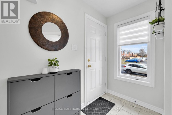 Hallway with octagonal window, bathroom access, and plant decor - 1344 Guthrie Street, Ottawa