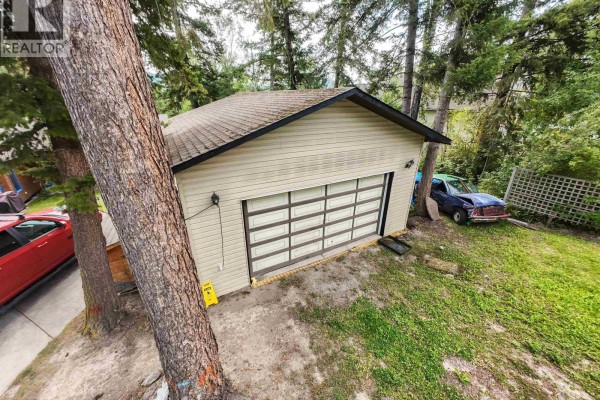 Interior view of a room with wood paneling, laminate flooring, and artwork on walls. - 1344 Lakeview Drive, Quesnel