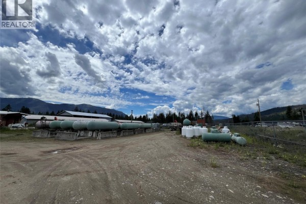 Outdoor storage yard with rows of green propane tanks under a dramatic cloudy sky. - 1345 Cardy Drive, Scotch Creek