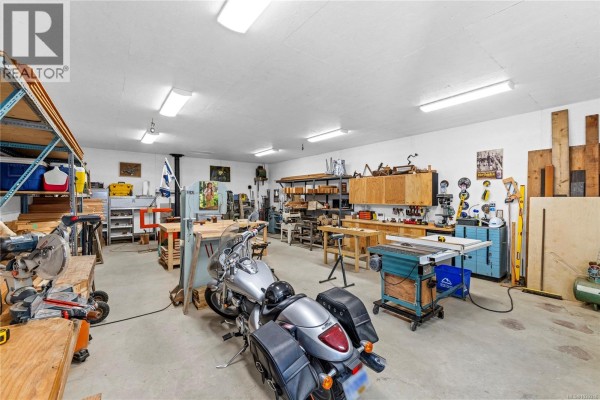 Several small wooden outbuildings and a larger workshop-style building on grassy lot. - 13475 Cedar Rd, Ladysmith