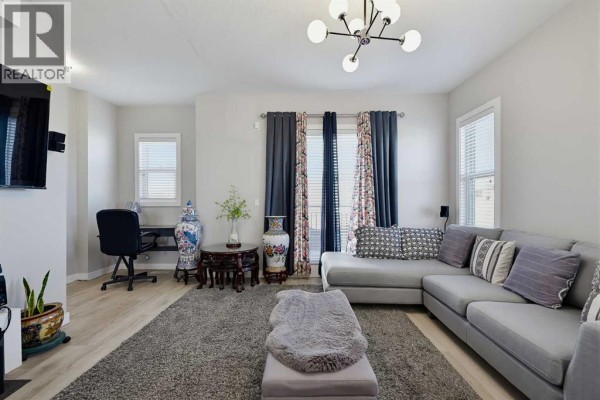 Living room featuring a sectional sofa, ottoman, decorative vases, and windows. - 135, 30 Cornerstone Manor Ne, Calgary