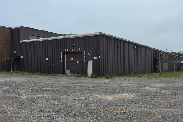 Rear exterior of commercial building with dark brown metal siding and garage door. - 135-161 Main Street, Burin
