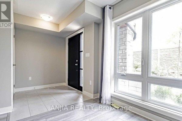 Interior entryway with tile flooring, a black door, and a large window with light curtains. - 135 Carpaccio Avenue, Vaughan