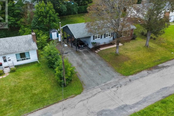 Aerial view of a bungalow with a driveway, carport, and neighboring house. - 135 Chelsea Court, New Glasgow
