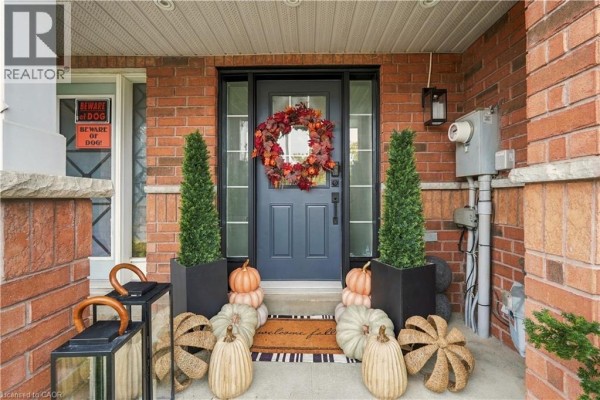 Front door with fall decorations including pumpkins, lanterns, and a wreath. - 135 Spicebush Terrace, Brampton