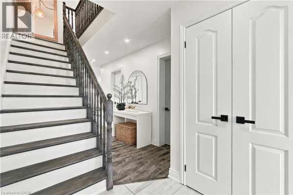 View of staircase leading upstairs with white risers and dark wood treads. - 135 Spicebush Terrace, Brampton