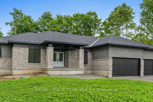 Side view of the home showing the garage doors and entrance. - 135 Upton Drive, Beckwith